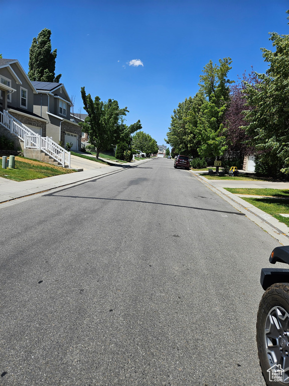 View of asphalt road with sidewalks, curbs, and a residential view