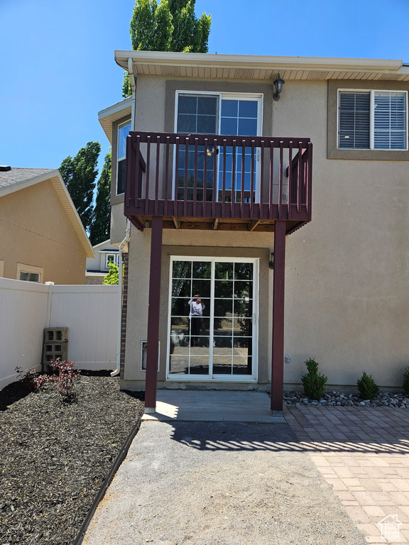 Rear view of house featuring stucco siding and a balcony