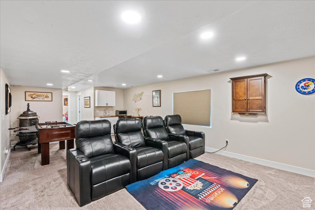 Home theater featuring indoor wet bar, baseboards, recessed lighting, and light colored carpet