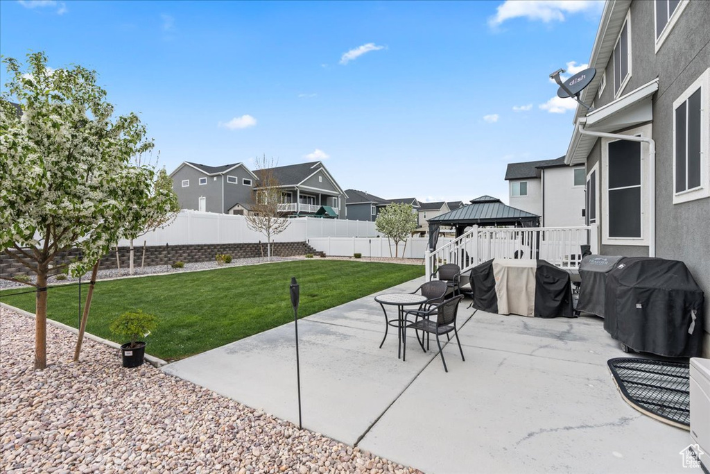 View of patio / terrace with grilling area, a fenced backyard, a gazebo, and a residential view