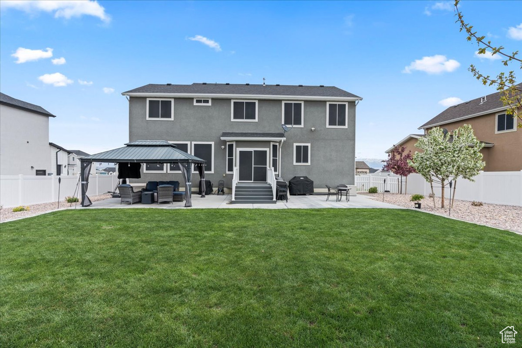Back of house with a fenced backyard, a gazebo, outdoor lounge area, a patio area, and entry steps