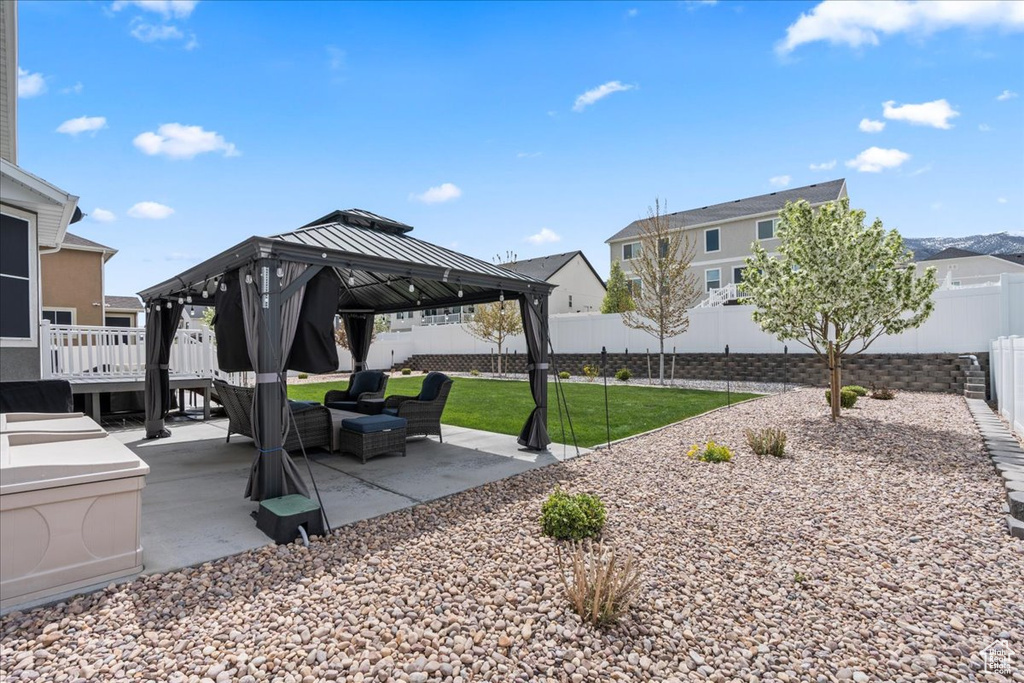 View of property's community with a fenced backyard, a gazebo, outdoor lounge area, a yard, and a patio