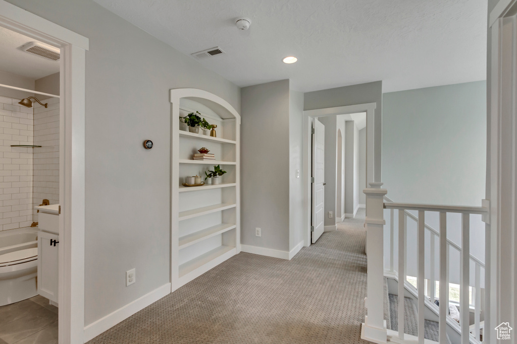 Hall with visible vents, baseboards, and carpet flooring