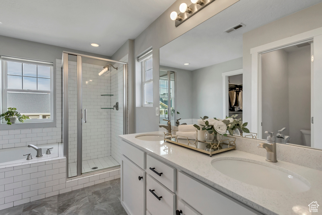 Bathroom featuring a sink, a wealth of natural light, and a stall shower