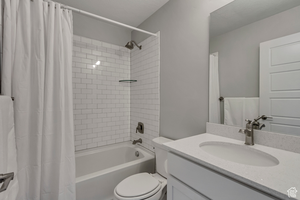 Full bath with shower / tub combo, toilet, and vanity