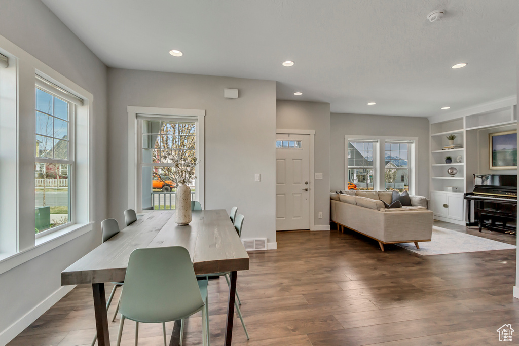 Dining space with a healthy amount of sunlight, visible vents, and wood finished floors