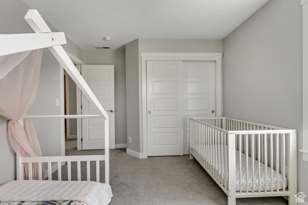 Bedroom with a closet, baseboards, carpet, and visible vents