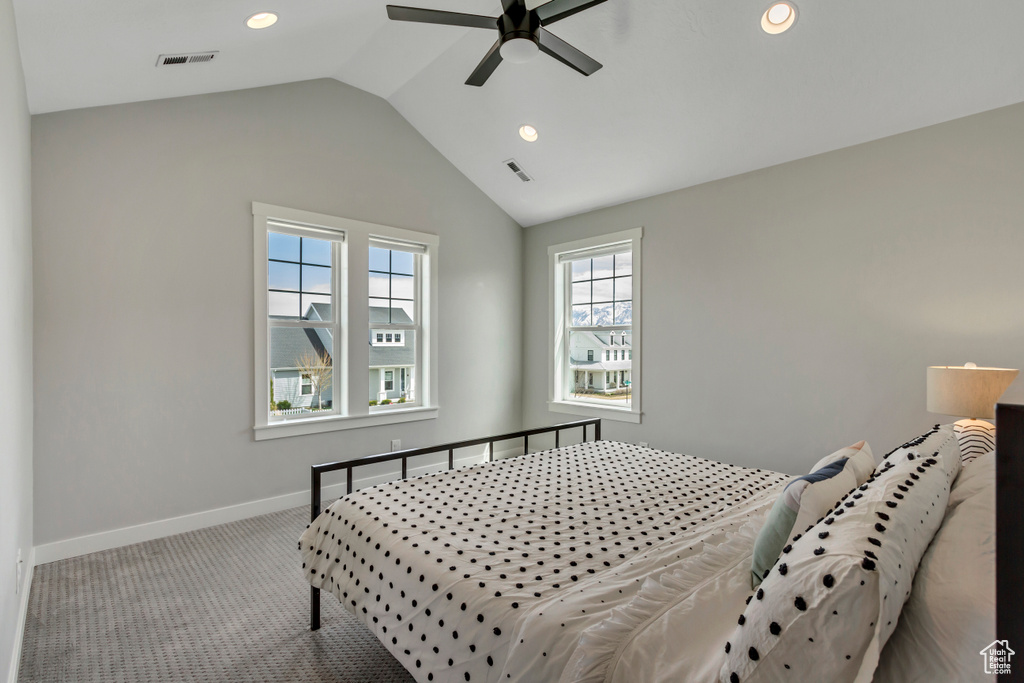 Bedroom with baseboards, vaulted ceiling, carpet, and visible vents