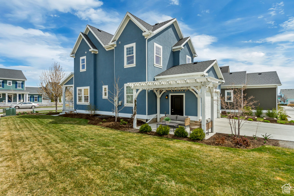 Rear view of property with a pergola, an outdoor hangout area, stucco siding, a lawn, and an attached garage