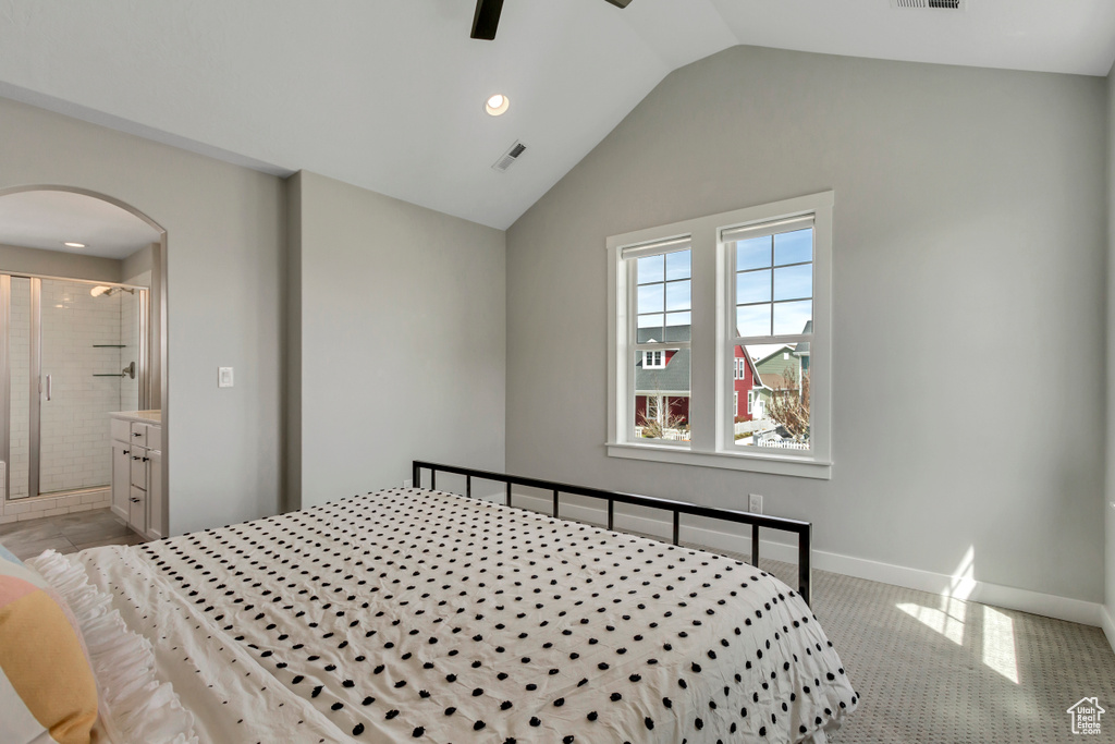 Bedroom with visible vents, baseboards, arched walkways, ensuite bath, and lofted ceiling