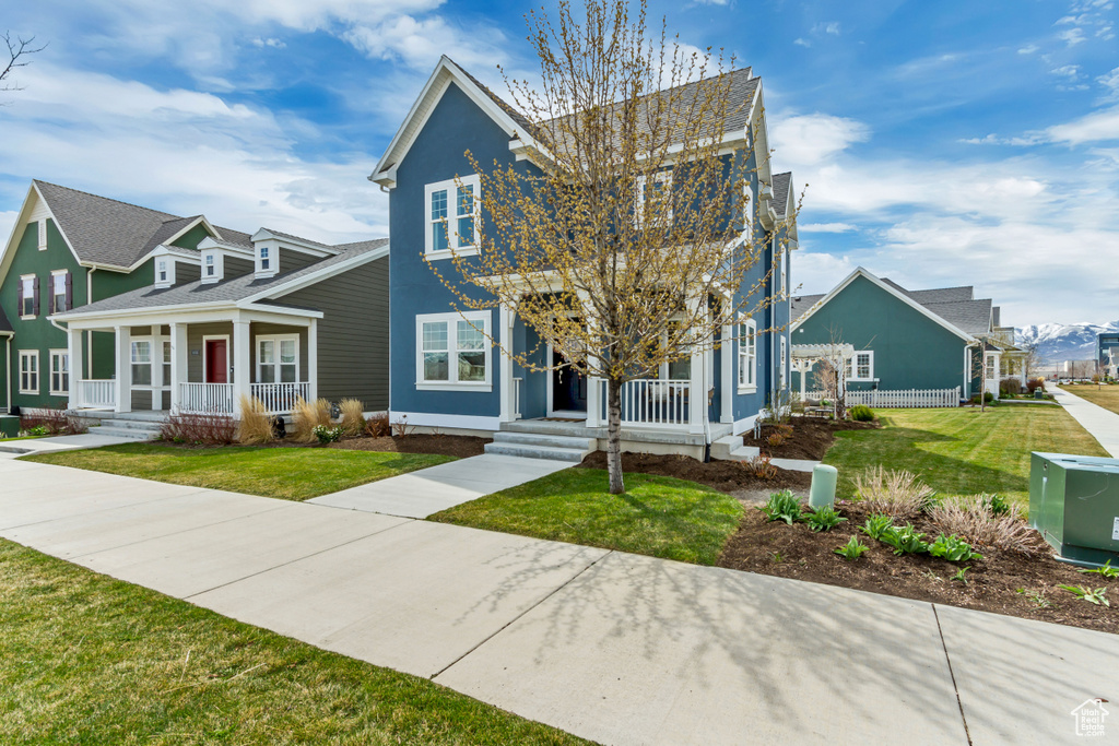 View of front of property with a front yard and covered porch