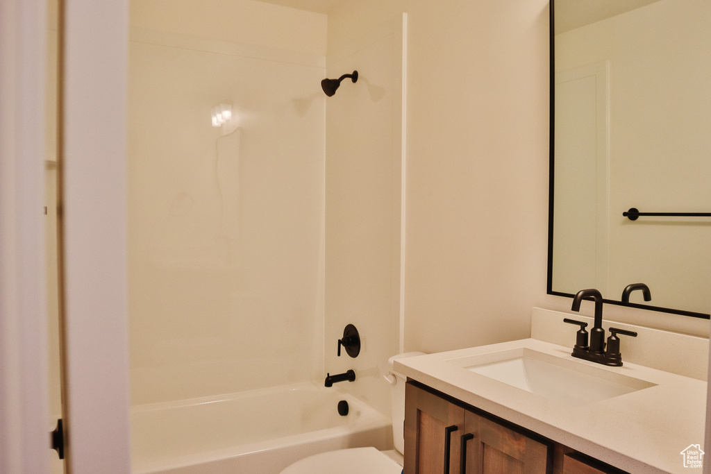 Full bathroom featuring toilet, vanity, and tub / shower combination