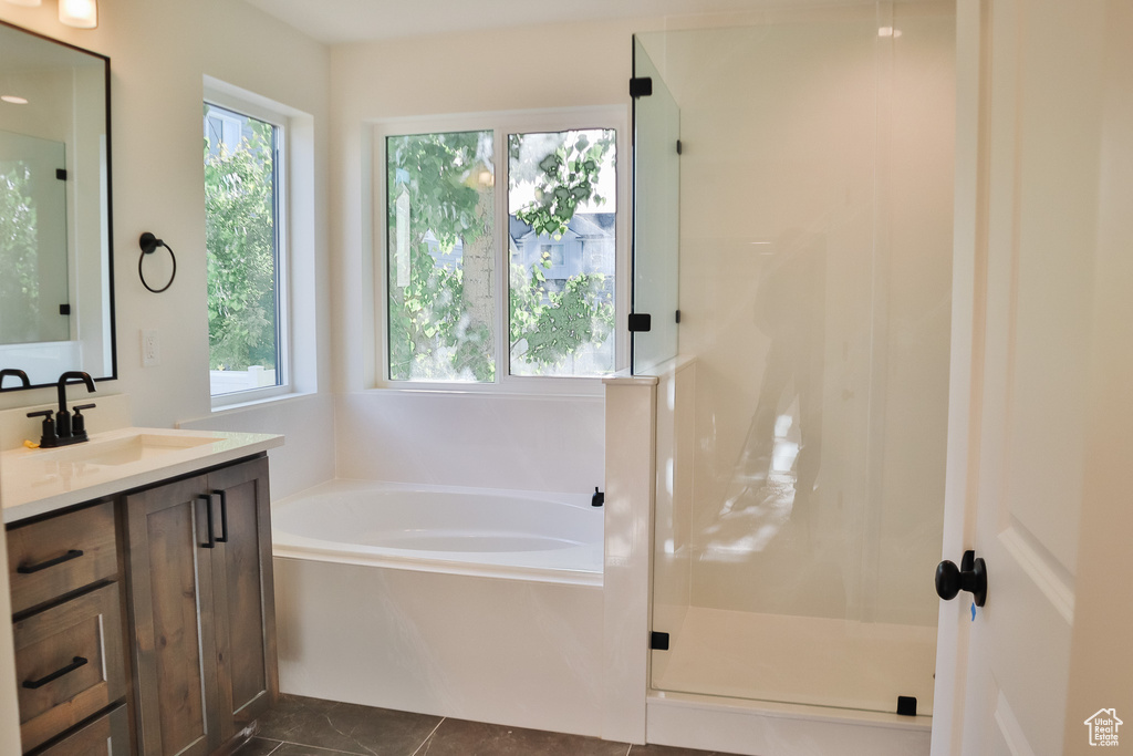 Full bath with a garden tub, vanity, a stall shower, and tile patterned flooring