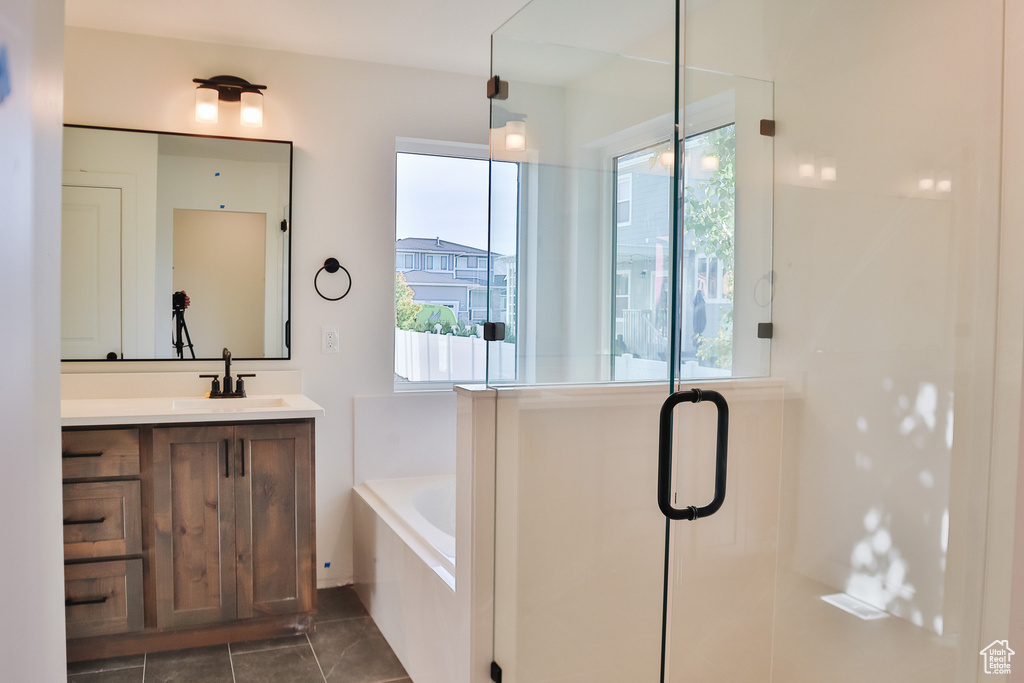 Bathroom with healthy amount of natural light, a bath, vanity, and a shower stall