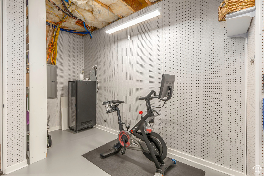 Exercise room featuring electric panel and baseboards