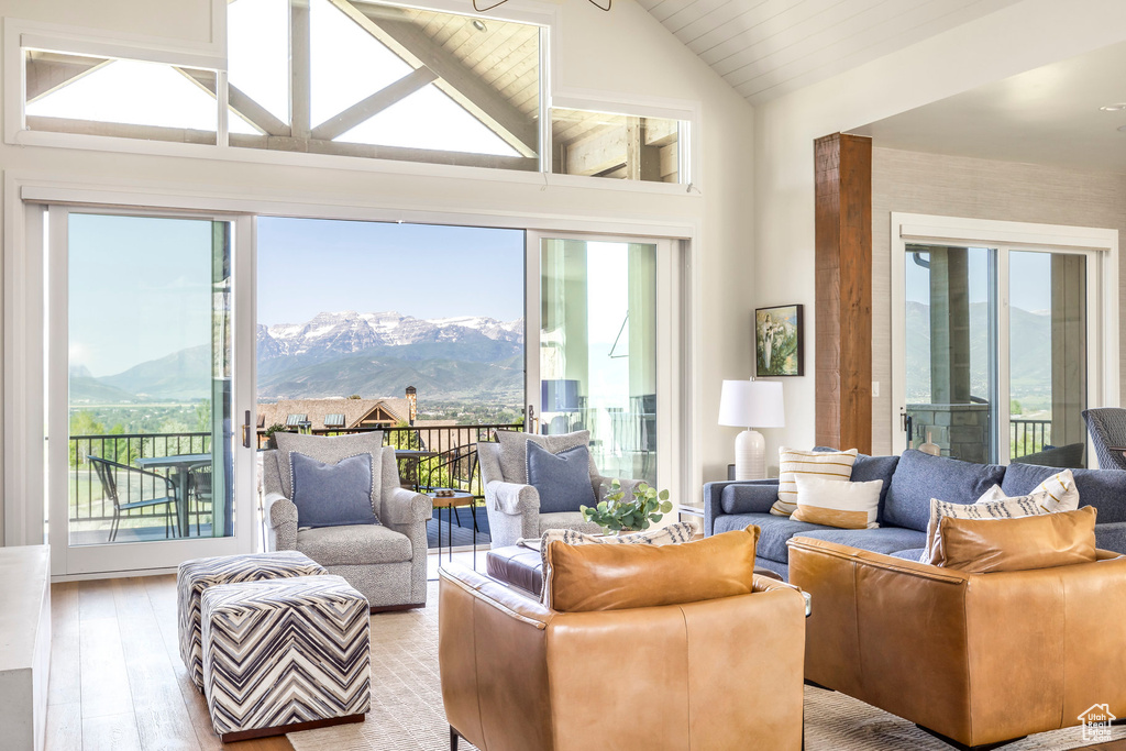 Living area featuring a mountain view, light wood-style floors, and high vaulted ceiling