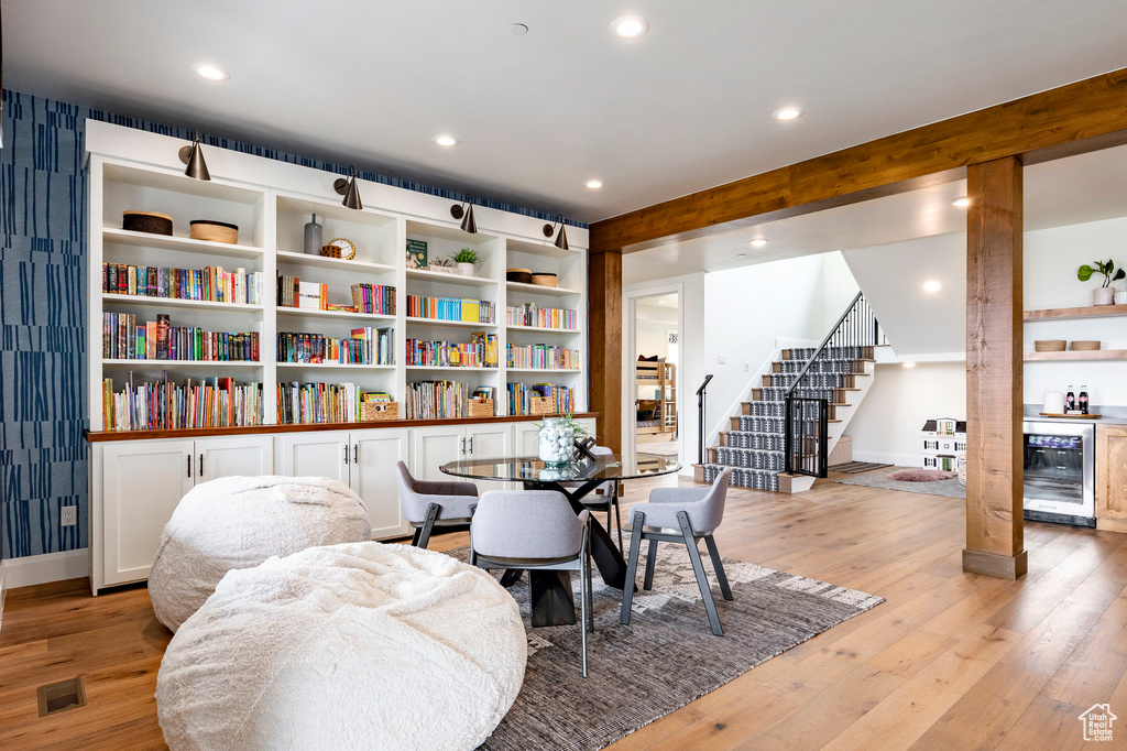 Dining area featuring beverage cooler, stairs, light wood-style flooring, recessed lighting, and baseboards