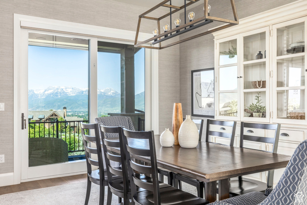 Dining room with wood finished floors, a mountain view, healthy amount of natural light, and wallpapered walls