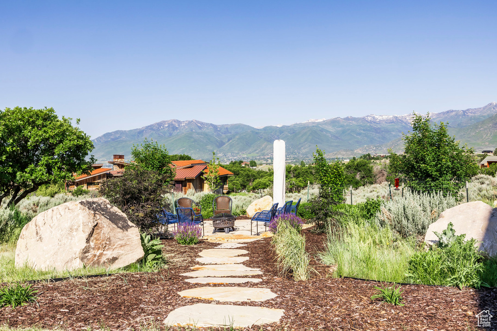 View of yard featuring a fire pit, a mountain view, and a patio