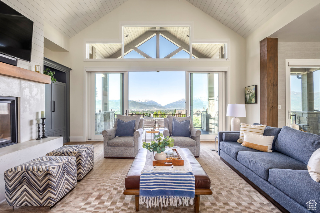 Living area with a high end fireplace, high vaulted ceiling, plenty of natural light, and a mountain view
