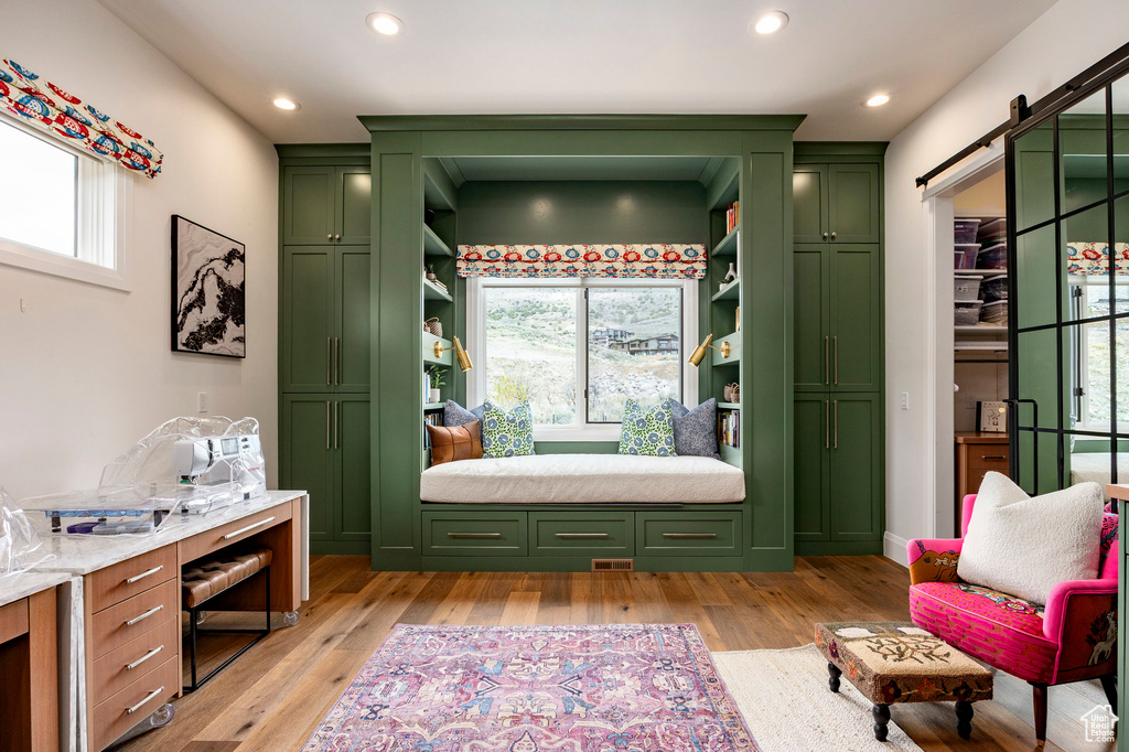 Sitting room with a barn door, light wood-style floors, and recessed lighting