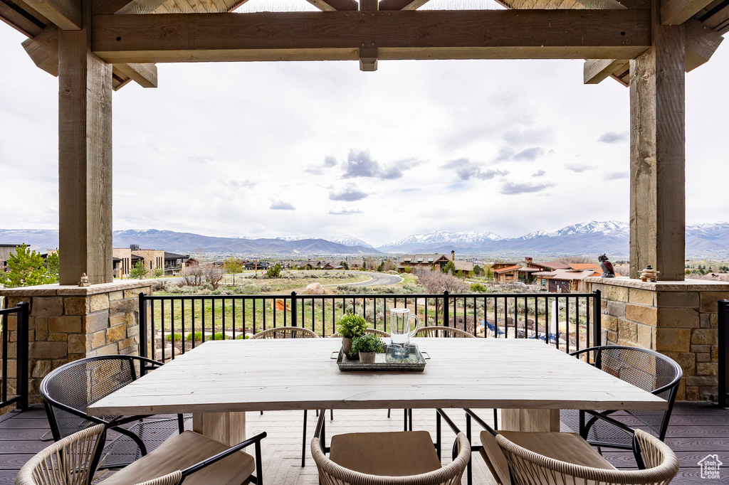 Wooden deck with outdoor dining space and a mountain view
