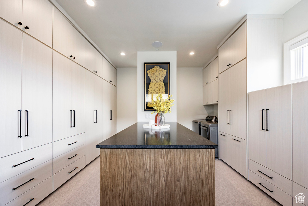 Walk in closet with washing machine and dryer and light carpet