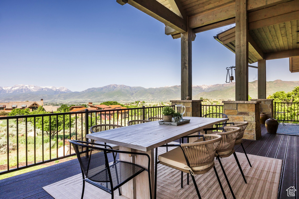 Wooden terrace featuring a mountain view and outdoor dining space