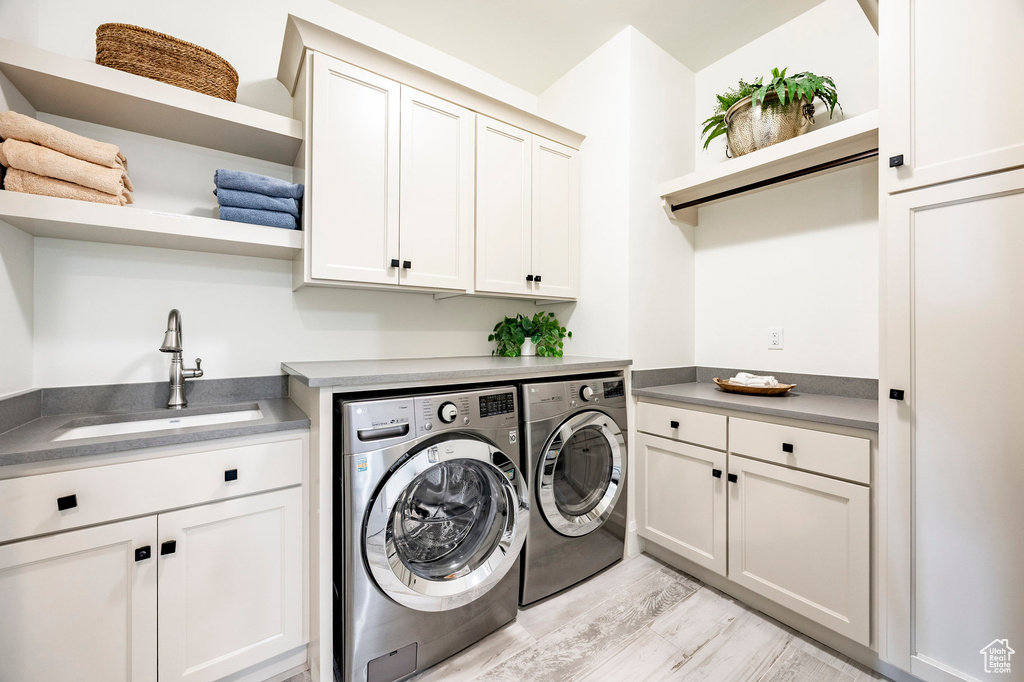 Laundry area featuring independent washer and dryer and cabinet space