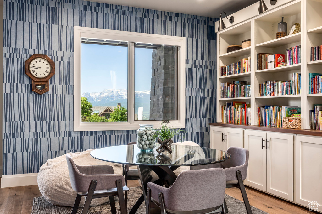 Sitting room featuring wallpapered walls, light wood finished floors, a mountain view, and baseboards