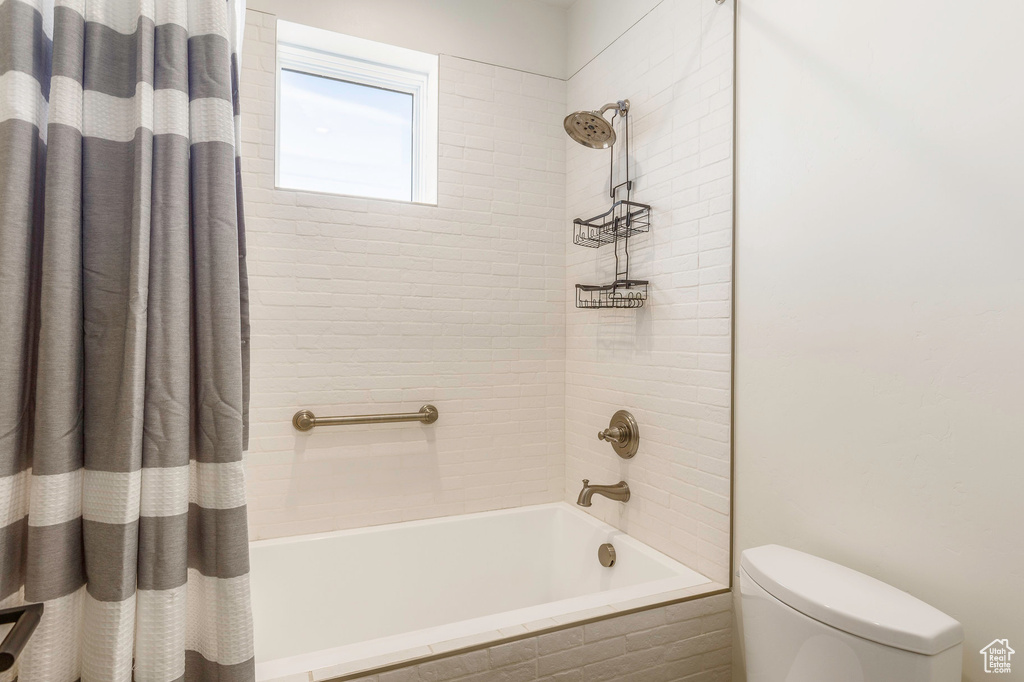 Full bath with shower / bath combination with curtain and toilet