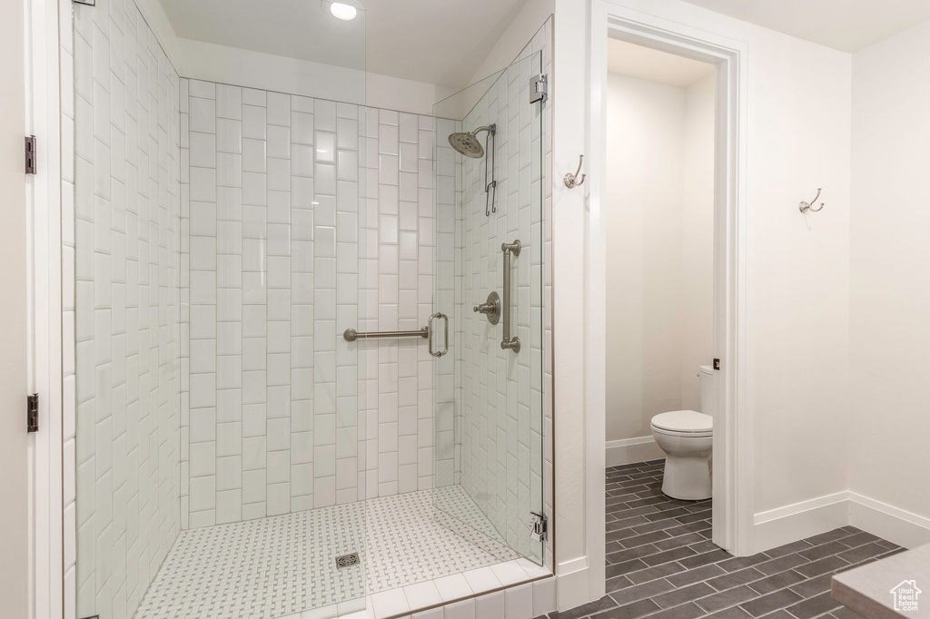 Full bath featuring a stall shower, toilet, baseboards, and recessed lighting