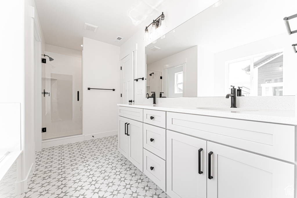 Full bathroom featuring a stall shower, double vanity, tile patterned floors, and a bath