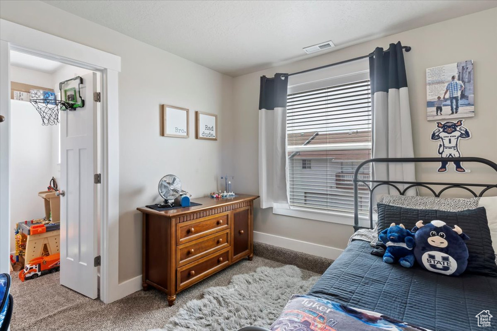 Carpeted bedroom with visible vents and baseboards