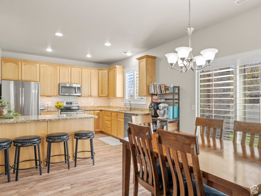 Interior space with light wood-style flooring, a notable chandelier, visible vents, and recessed lighting