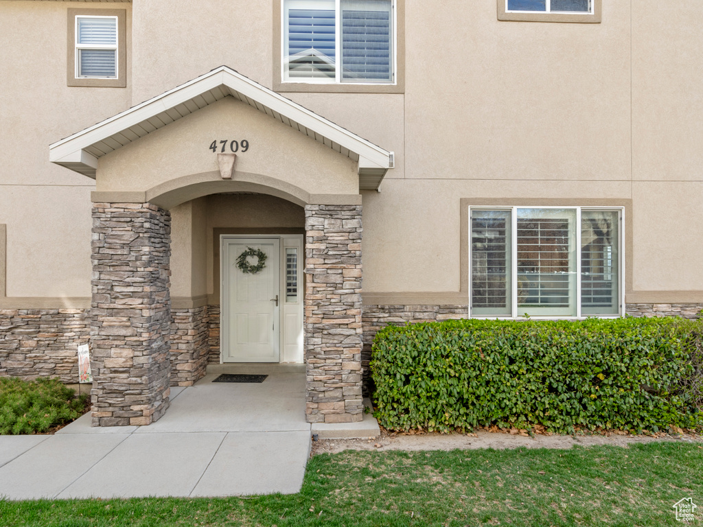 Entrance to property featuring stucco siding and stone siding