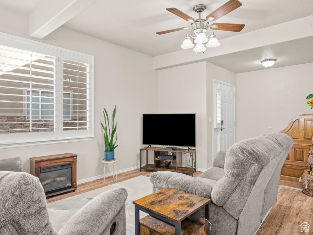 Living room featuring a healthy amount of sunlight, baseboards, wood finished floors, and ceiling fan