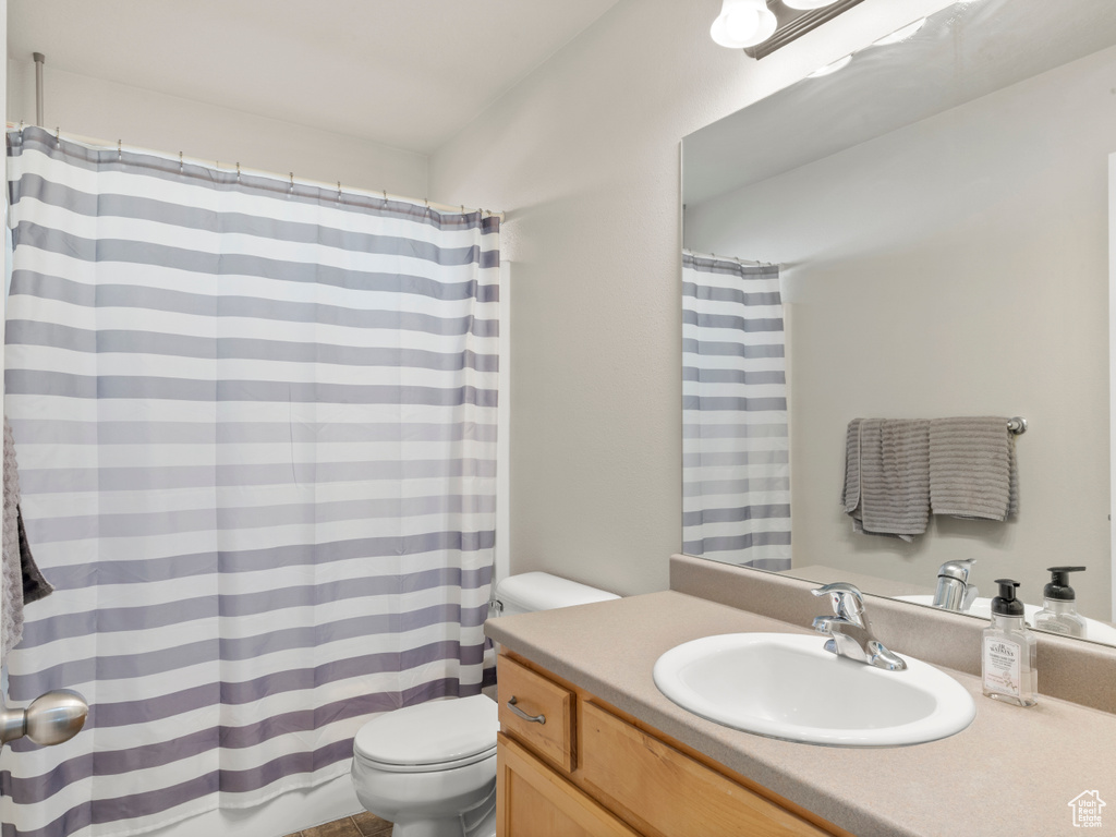 Full bath featuring toilet, vanity, and a shower with curtain