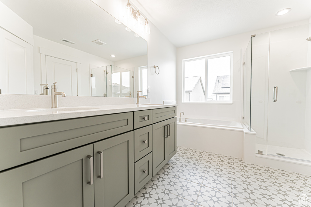 Bathroom with a shower stall, double vanity, a bath, and tile patterned floors