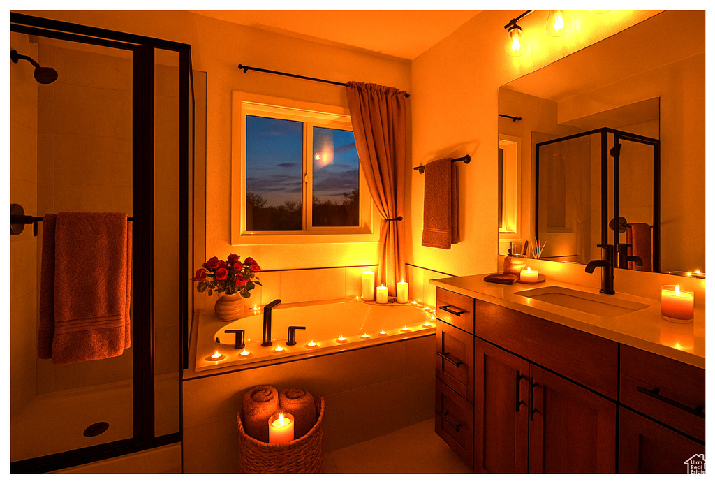 Bathroom featuring a garden tub, a stall shower, and vanity