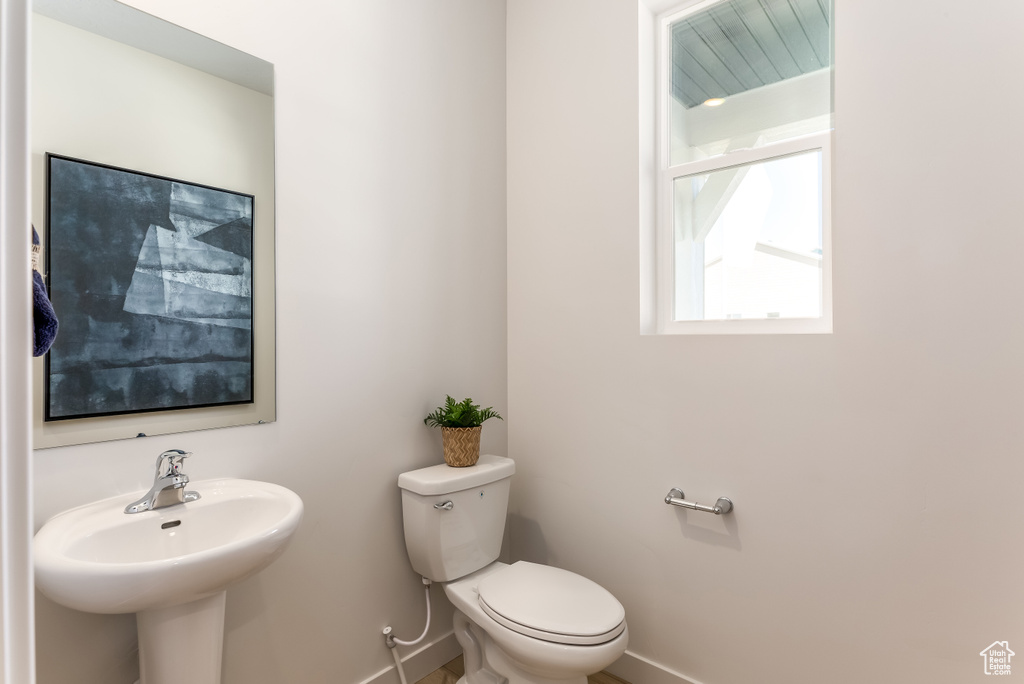 Bathroom with toilet, a sink, and baseboards