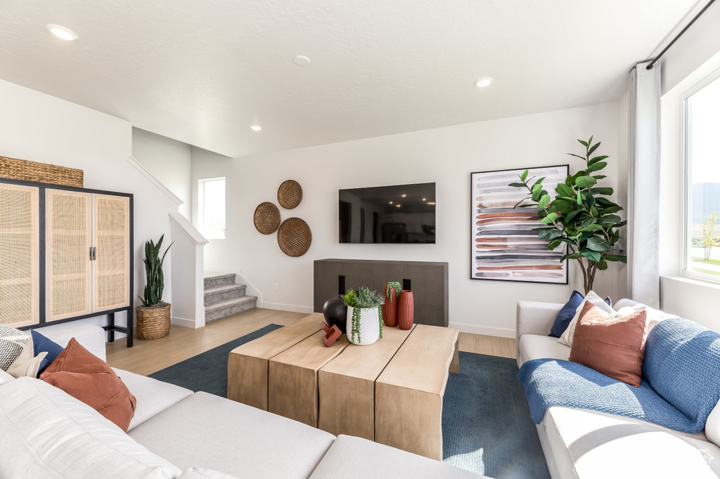 Living area featuring plenty of natural light, stairway, and wood finished floors