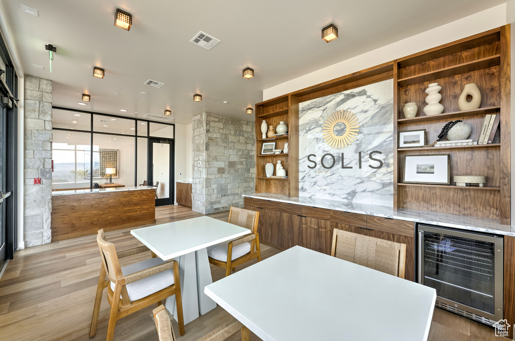 Bar featuring wine cooler, light wood-type flooring, visible vents, and expansive windows