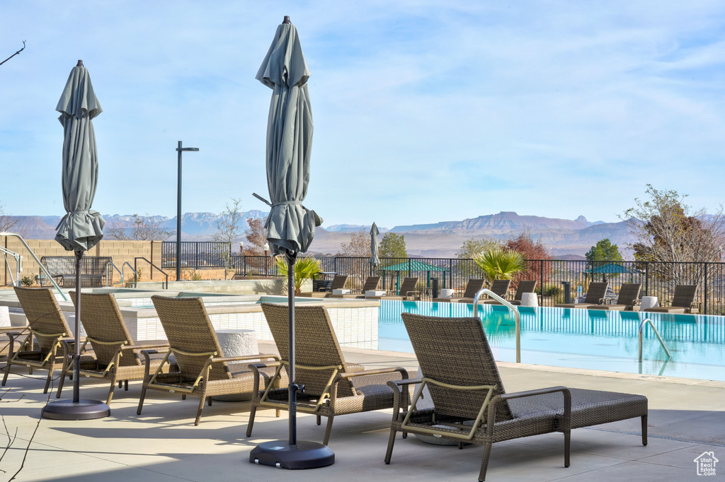 Pool featuring a mountain view, a patio area, and fence