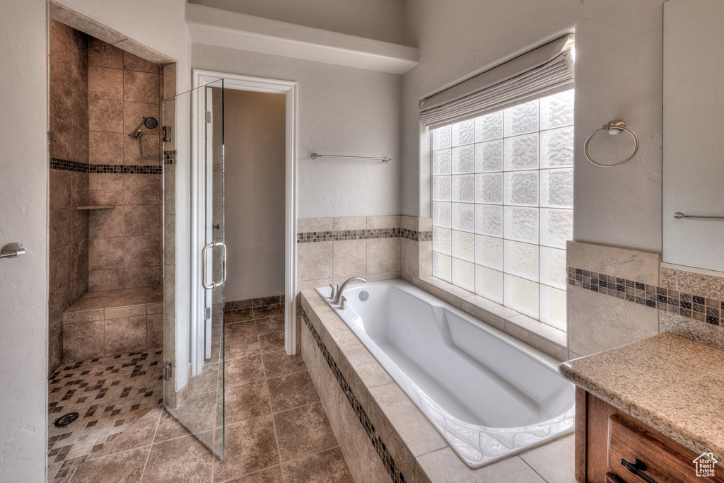 Full bath featuring a shower stall, tile patterned flooring, vanity, and a bath