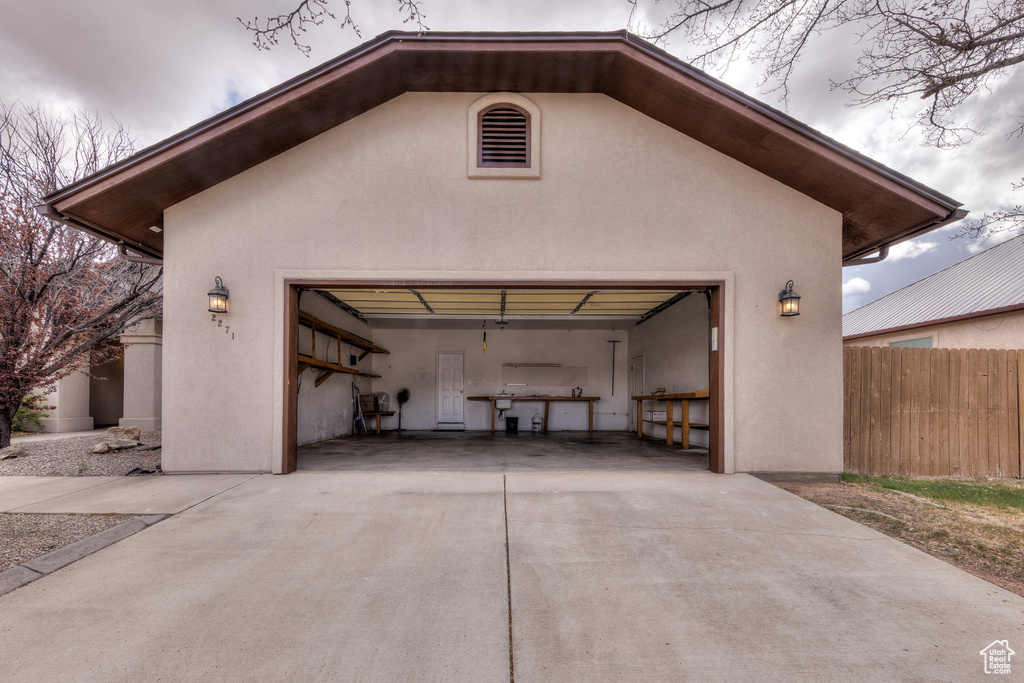 Garage with concrete driveway and fence