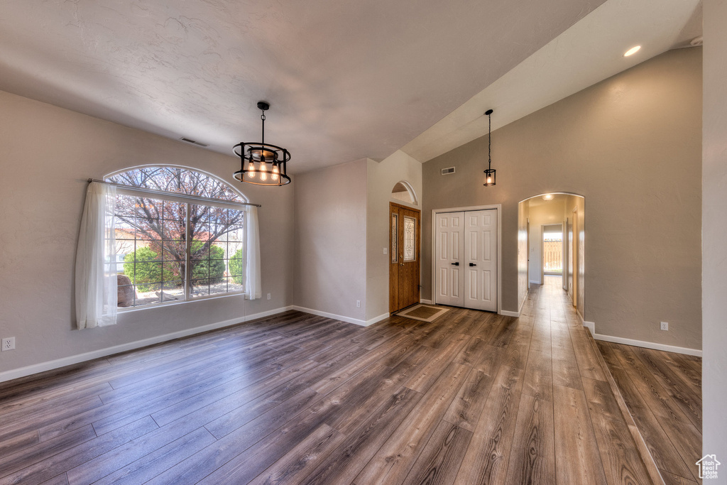 Entrance foyer featuring arched walkways, dark wood-style flooring, and baseboards