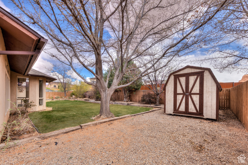 View of yard featuring a shed, a fenced backyard, and an outbuilding