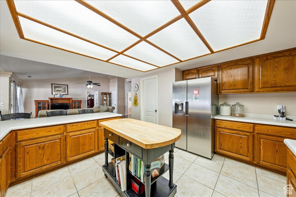 Kitchen featuring stainless steel refrigerator with ice dispenser, light countertops, and brown cabinetry