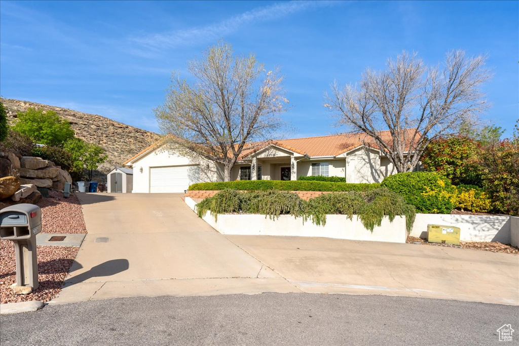 Single story home with stucco siding, a garage, and concrete driveway